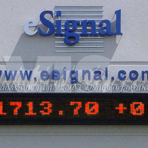 Electronic stock ticker display on building facade.