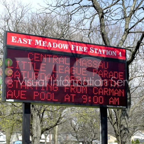 Fire station digital sign among trees.