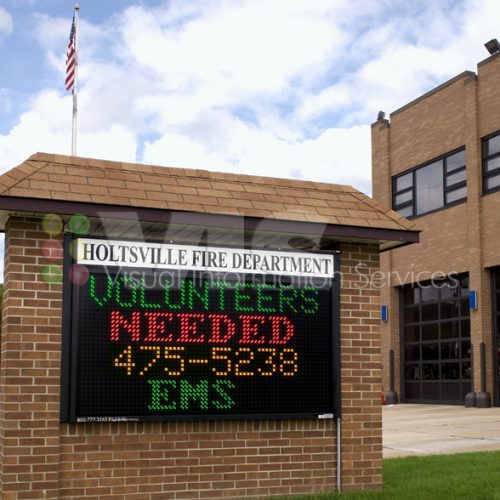 Fire department sign, volunteers needed information displayed.