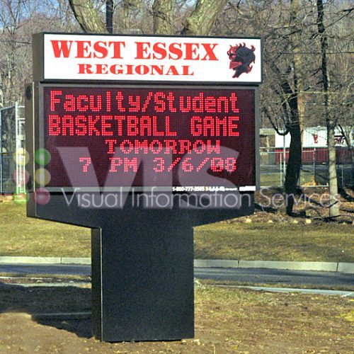 School sign announcing basketball game event.