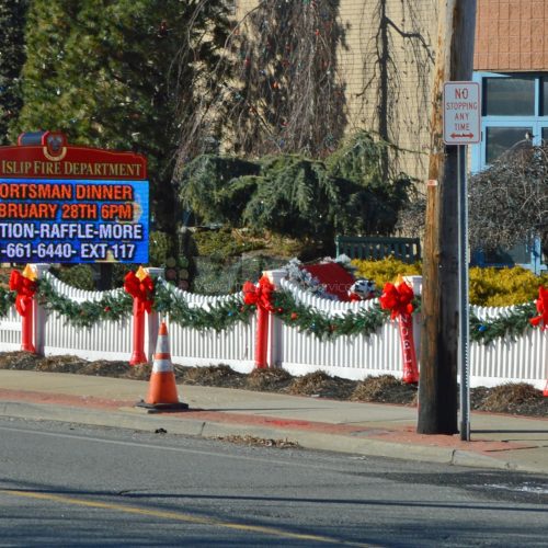 Christmas decorations and event sign on street.