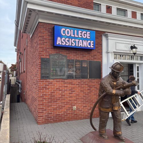 Statue of firefighter outside brick building.
