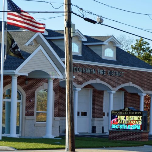 Brick fire station with American flag outside.