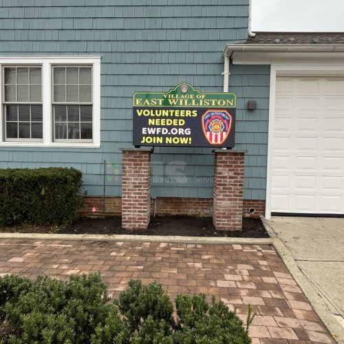 Building with "Volunteers Needed" sign outside.
